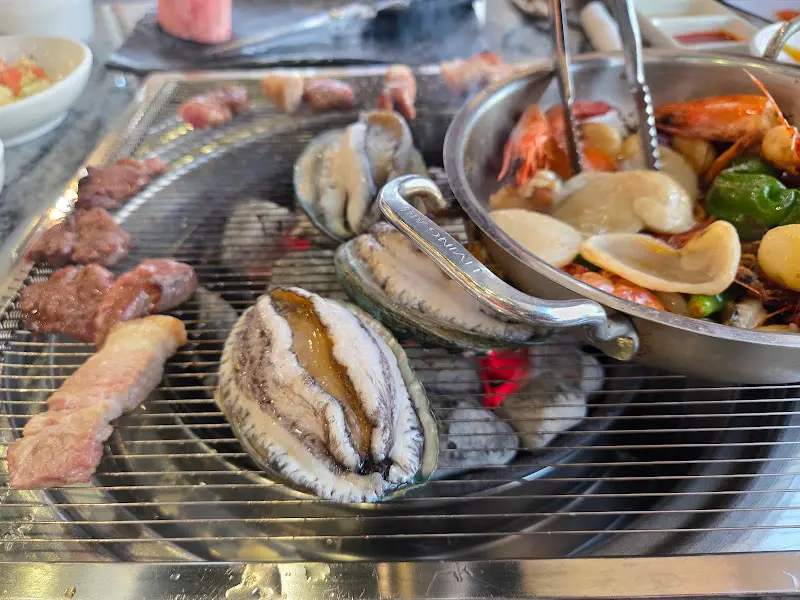 숯불 위에 구워지는 돼지갈비와 해산물