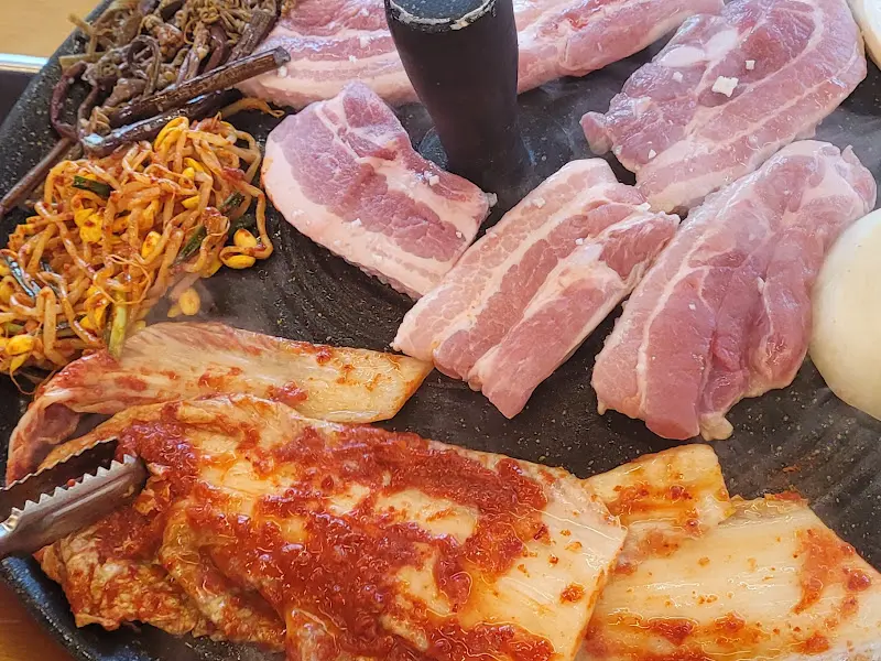 솥뚜껑 위에 구워지는 삼겹살과 김치