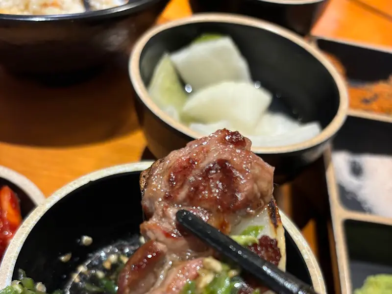 양념에 버무려진 양고기 한 점을 젓가락으로 집어 올리는 모습