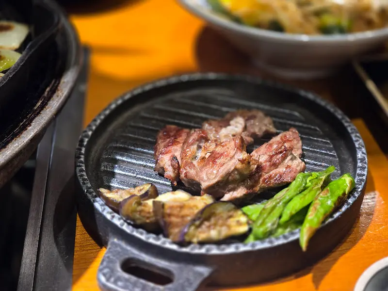 잘 구워진 양고기와 가지, 고추가 철판 위에 놓여 있는 모습