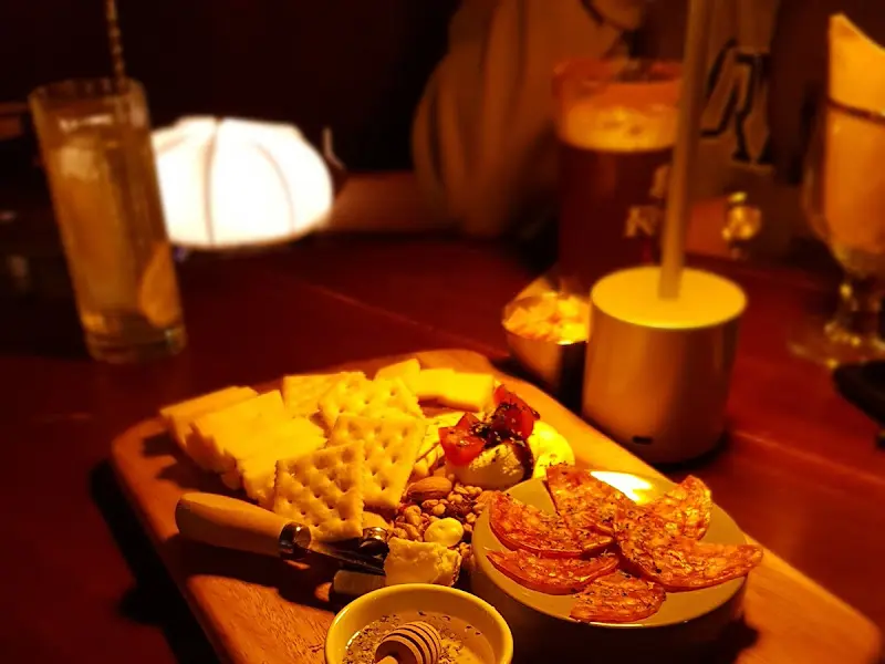 테이블 위에 놓인 치즈 플레이트와 술