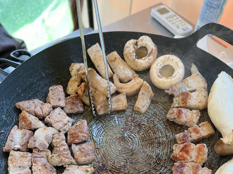 불판 위에서 구워지는 고기와 버섯