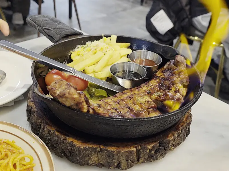 뜨거운 팬에 담겨 나오는 통삼겹스테이크