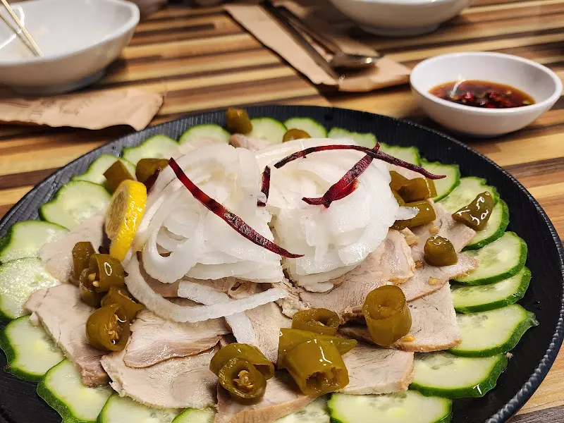 장육 위에 채 썬 양파와 붉은 고추가 올려져 있다.