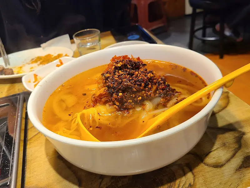 매콤한 양념이 듬뿍 올려진 온면의 클로즈업 사진