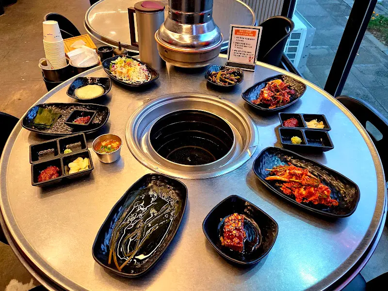 테이블에 가득 차려진 밑반찬과 흑돼지 구이