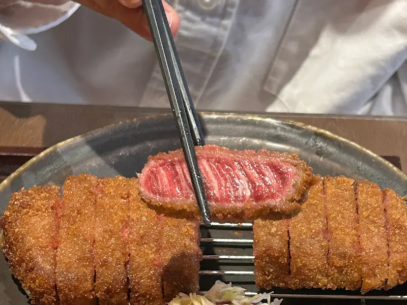 젓가락으로 집어 올린 규카츠 단면