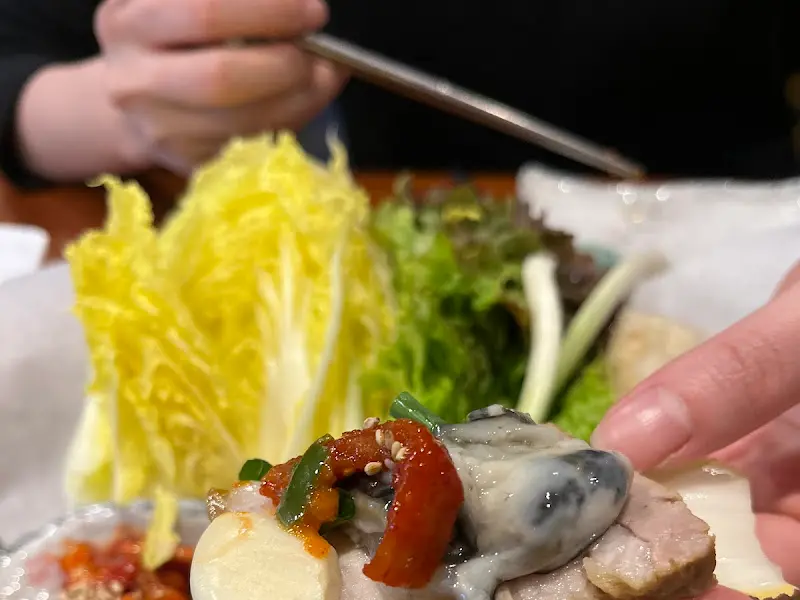 문어삼합을 쌈에 싸서 먹는 모습