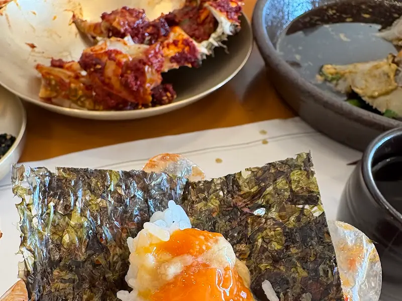 김에 밥과 게살을 싸 먹는 모습