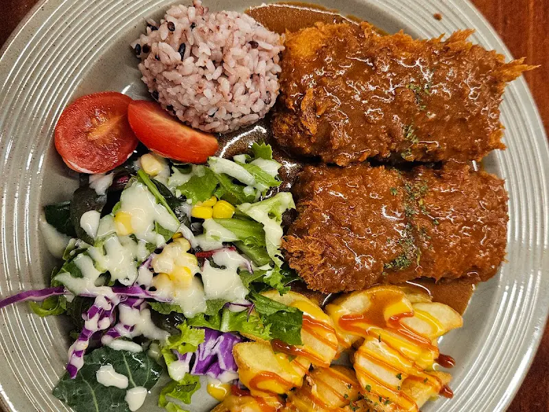 돈까스, 샐러드, 밥, 감자튀김이 한 접시에 담겨있는 모습