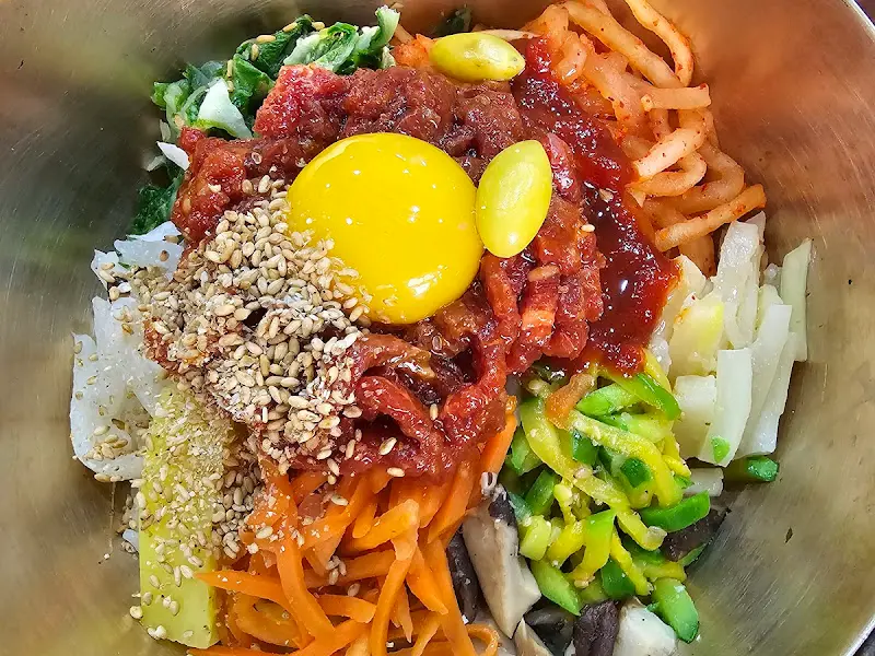놋그릇에 담긴 육회비빔밥의 화려한 비주얼