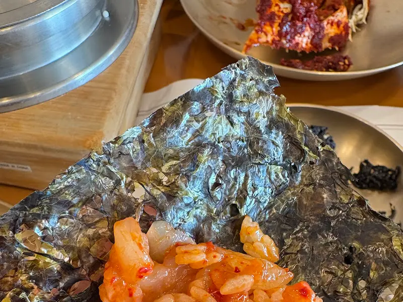 김에 밥과 양념게살을 싸 먹는 모습