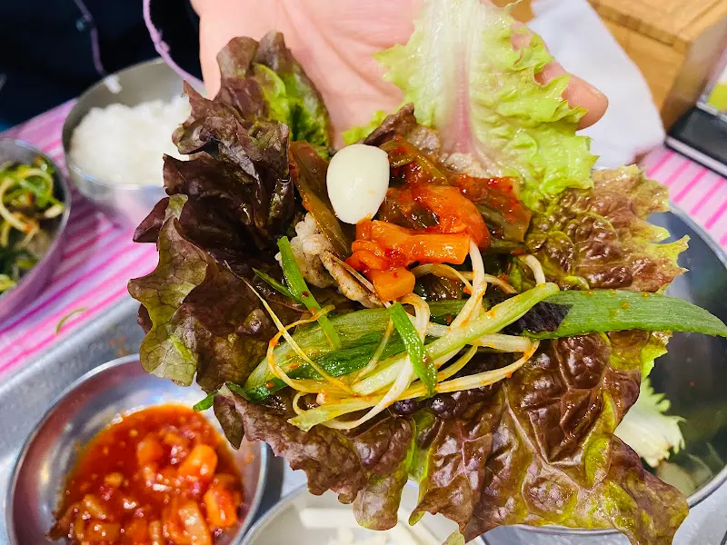 쌈 채소에 냉삼겹살과 대파김치를 올려 크게 한 쌈