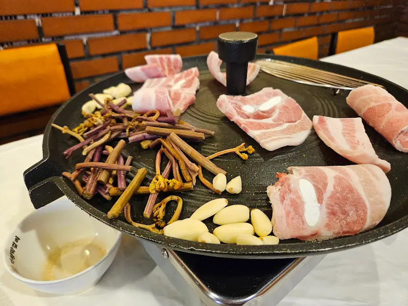 불판 위에 올려진 냉삼과 고사리, 마늘