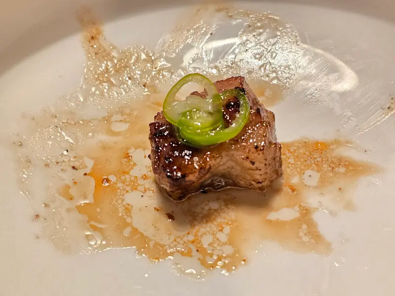 맛있게 구워진 고기 한 점을 접시에 담아낸 모습