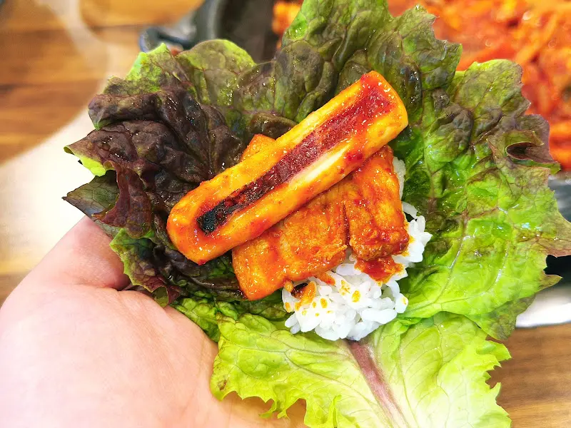 오삼불고기를 쌈 채소에 싸서 먹는 모습