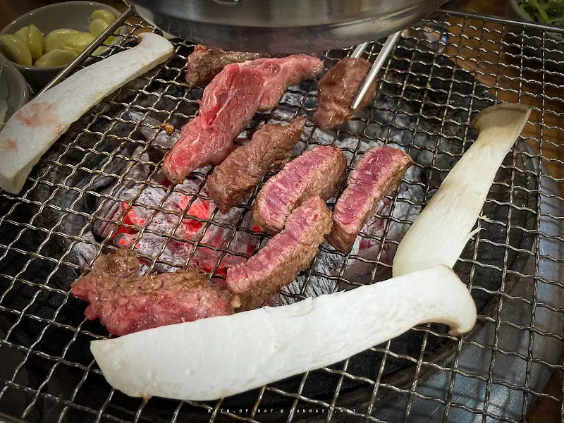 숯불 위에서 구워지는 고기와 버섯