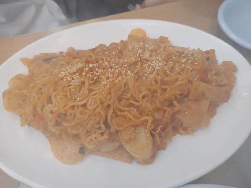 라볶이 클로즈업 사진. 떡, 면, 어묵이 붉은 양념에 버무려져 있다.