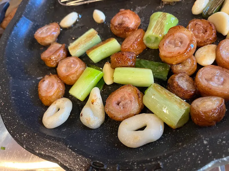 불판 가득 채운 막창, 대파, 마늘