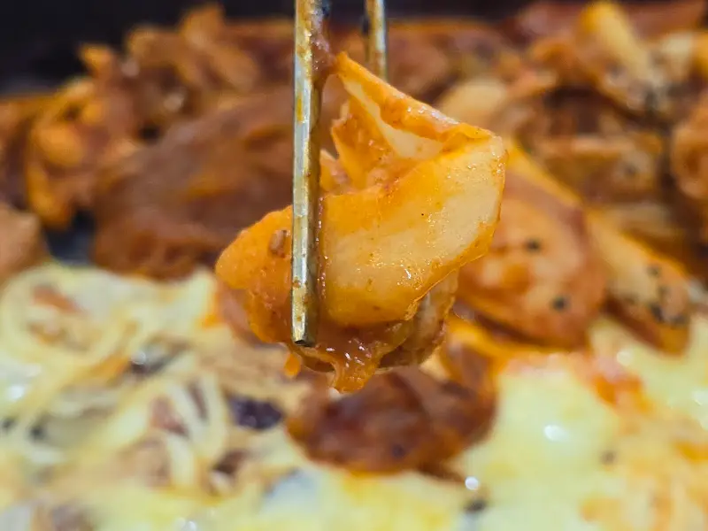 젓가락으로 들어올린 닭갈비 한 점