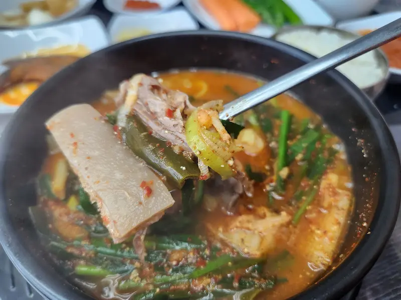 숟가락으로 떠올린 염소고기와 야채