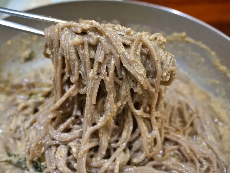 젓가락으로 집어 올린 들깨 막국수의 쫄깃한 면발