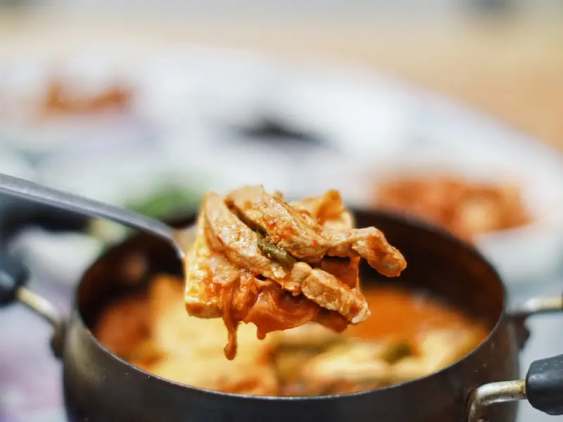 숟가락 위에 올려진 김치와 돼지고기