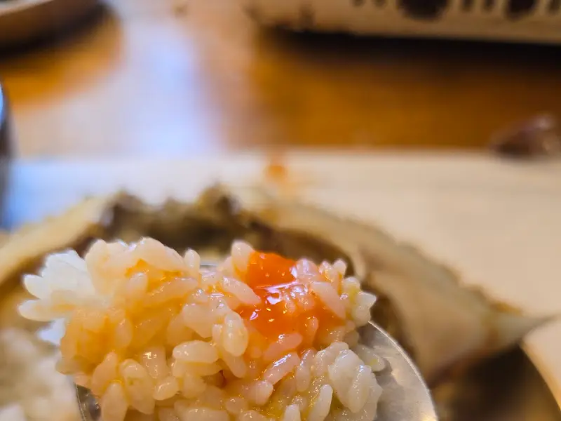 간장게장의 게살을 숟가락으로 떠서 밥에 올린 모습