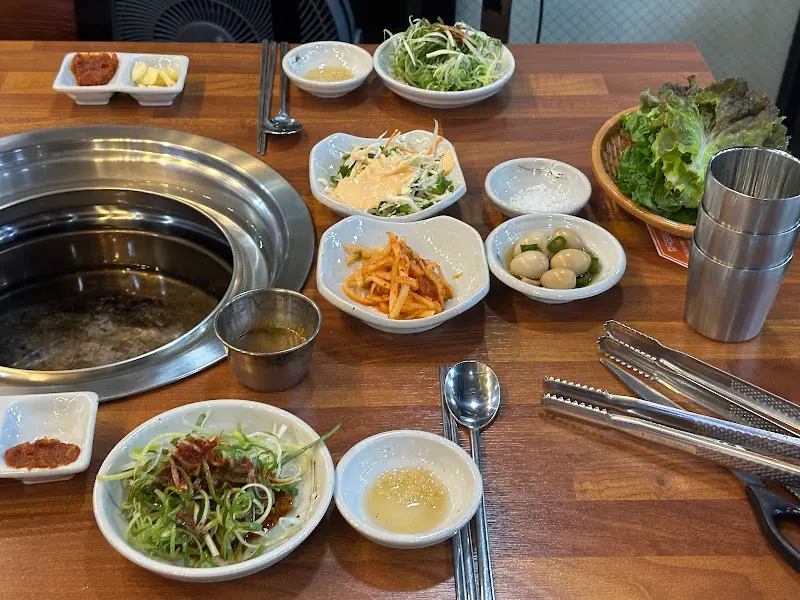 숯불 화로와 밑반찬이 놓인 테이블