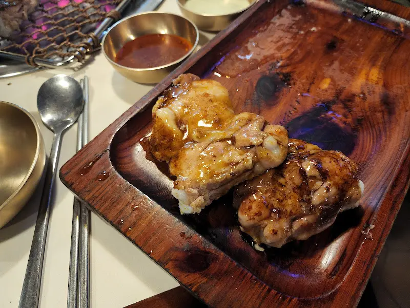 나무 쟁반 위에 가지런히 놓인 간장 양념 닭갈비