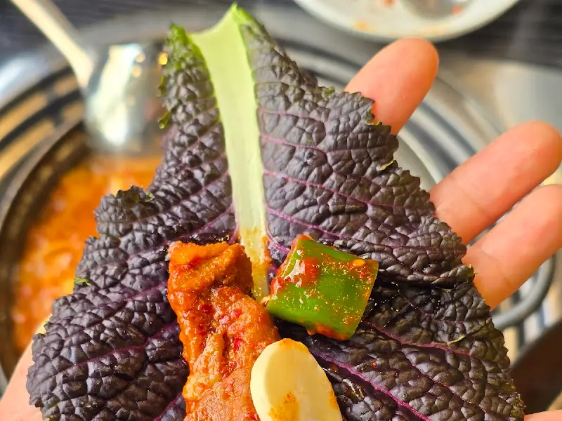 쌈을 크게 싸서 들고 있는 모습