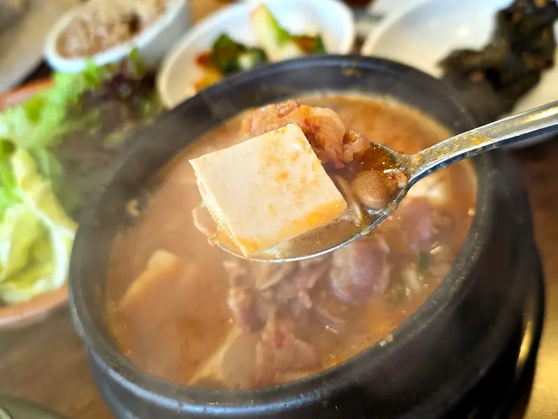 청국장 속 두부를 숟가락으로 뜨는 모습