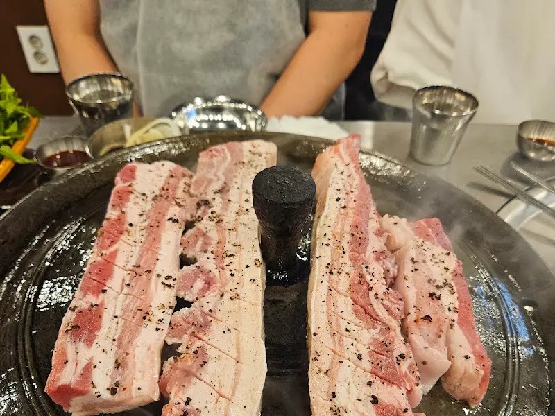 솥뚜껑 위에 올려진 두툼한 삼겹살