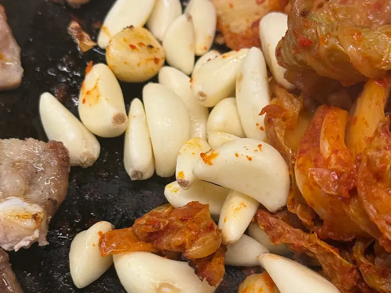 구워진 삼겹살, 김치, 마늘 클로즈업