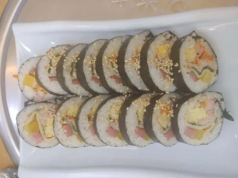 참치김밥 단면 사진. 밥알 사이로 다양한 속재료가 보인다.