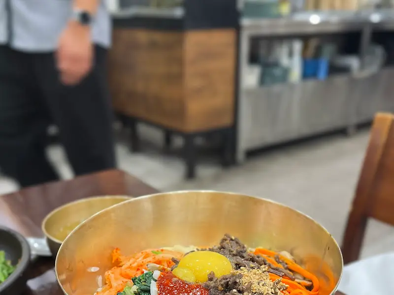 놋그릇에 담긴 비빔밥과 콩나물국, 그리고 다양한 밑반찬들