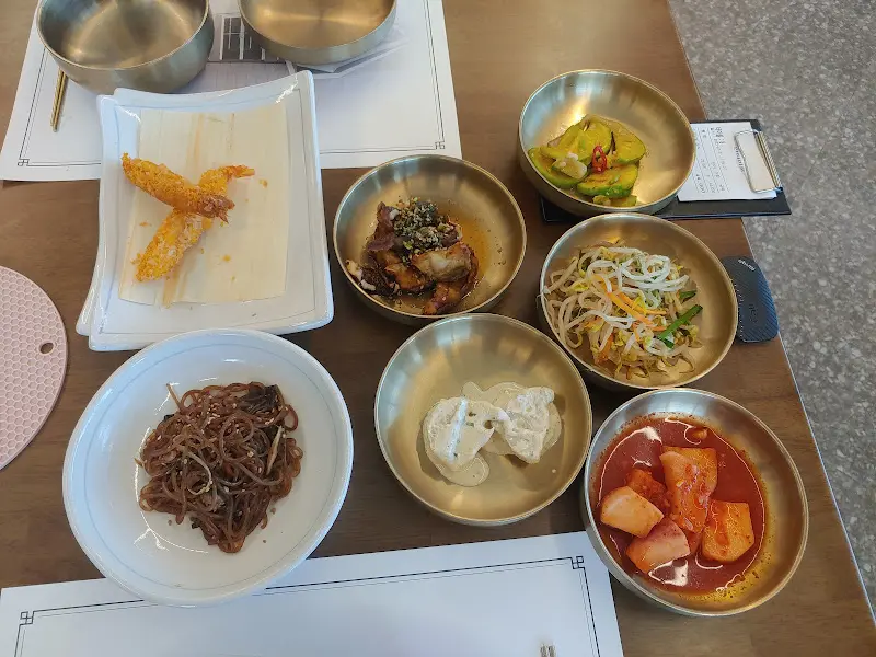 테이블 위에 여러 놋그릇에 담긴 다양한 반찬들이 놓여 있다.