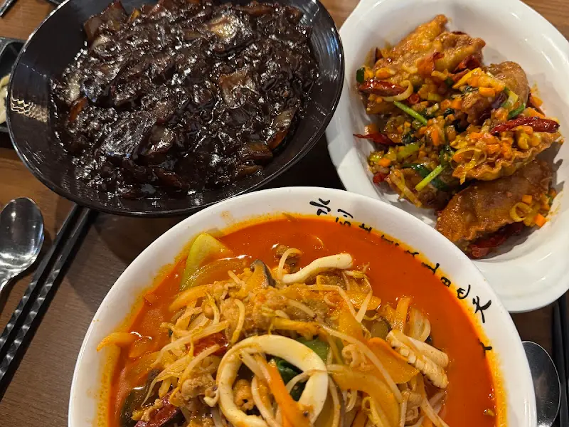 테이블 가득 차려진 짜장면, 짬뽕, 깐풍만두