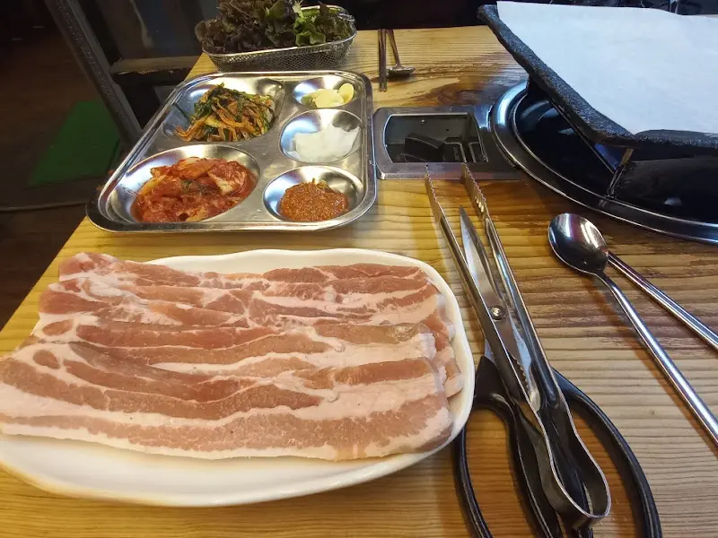 신선한 쌈 채소와 밑반찬이 차려진 테이블