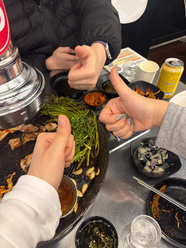 식사를 마친 후 엄지척 포즈를 취하고 있는 사람들의 모습