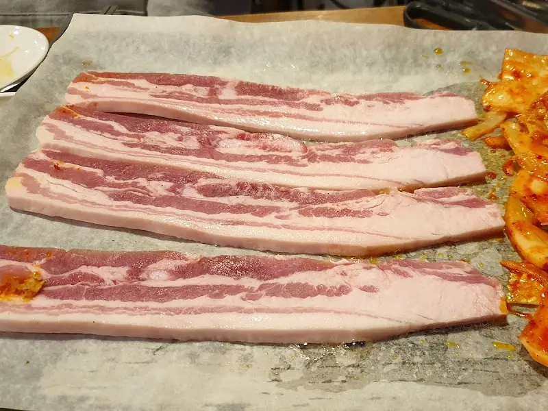 불판 위에 올려진 삼겹살과 김치