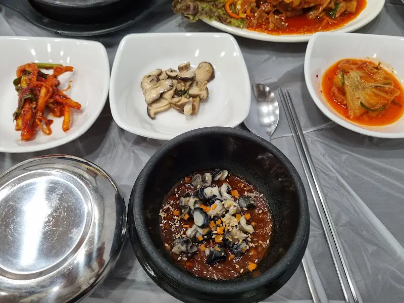 우렁쌈장, 제육볶음, 된장찌개, 밑반찬이 차려진 푸짐한 한 상