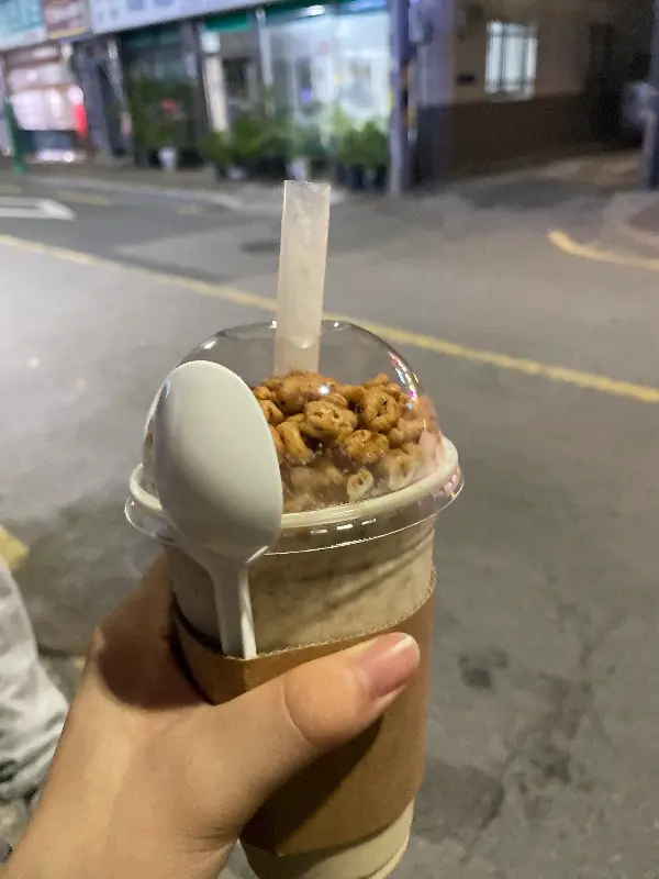 테이크 아웃 컵에 담긴 음료 위에 시리얼이 올려진 모습