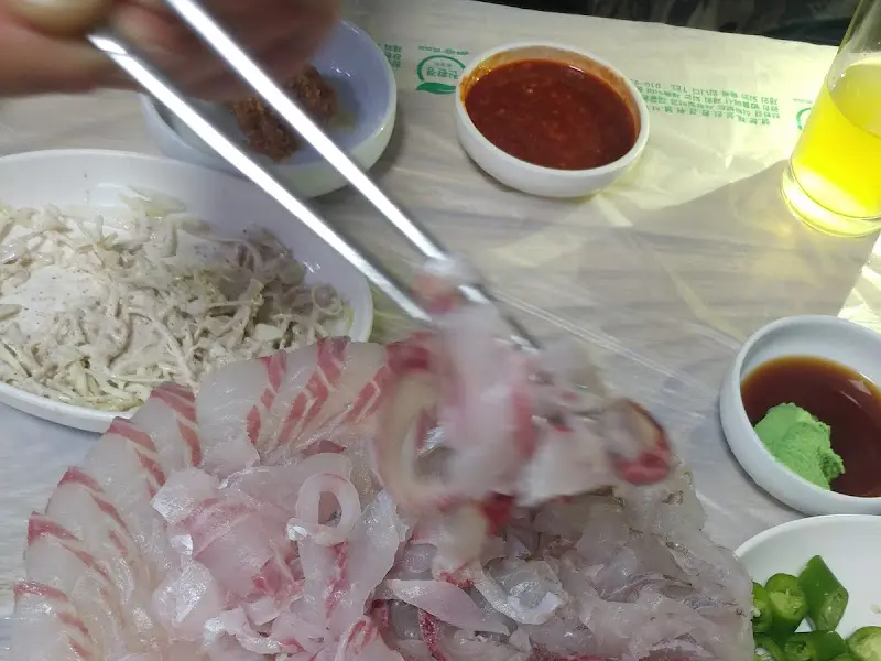 싱싱한 회를 젓가락으로 집는 모습