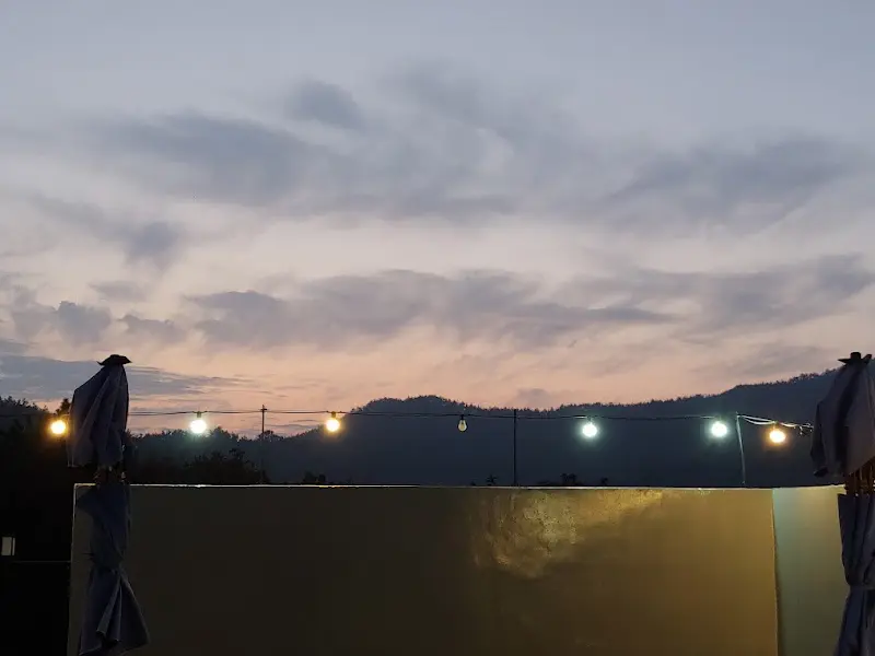 저녁 노을이 지는 캠핑장의 모습, 은은한 조명들이 낭만적인 분위기를 더한다.