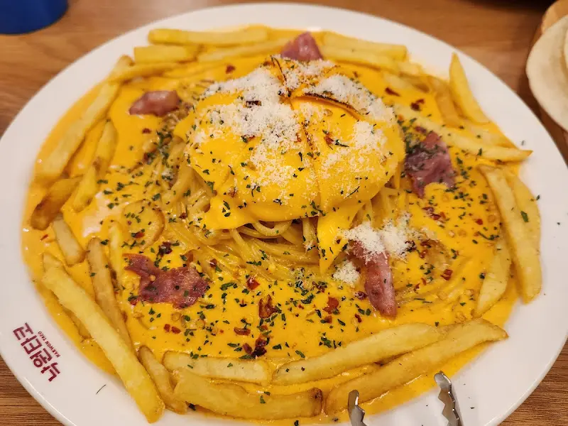 파스타 위에 감자튀김이 곁들여진 독특한 메뉴