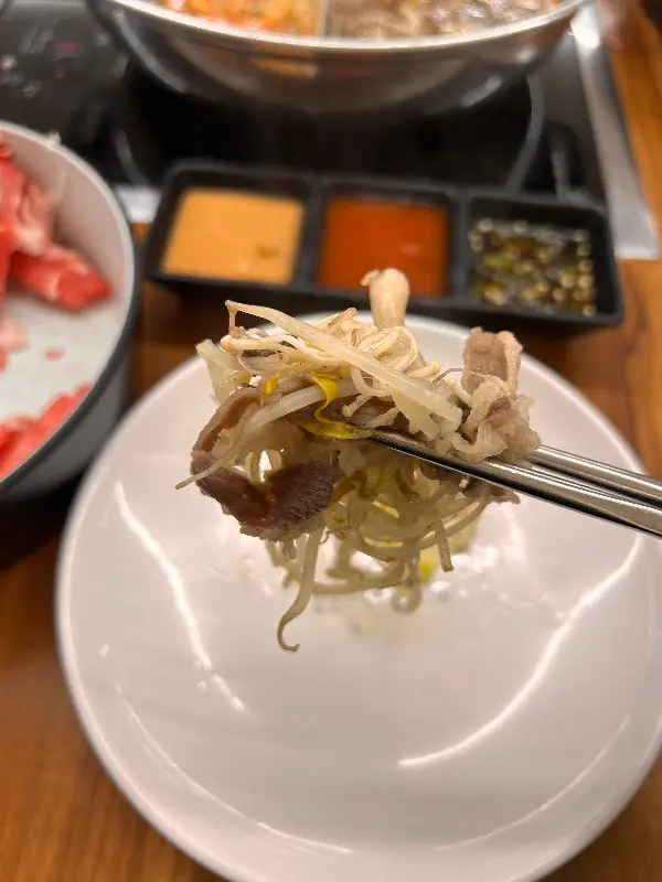 젓가락으로 집어 올린 소고기와 채소