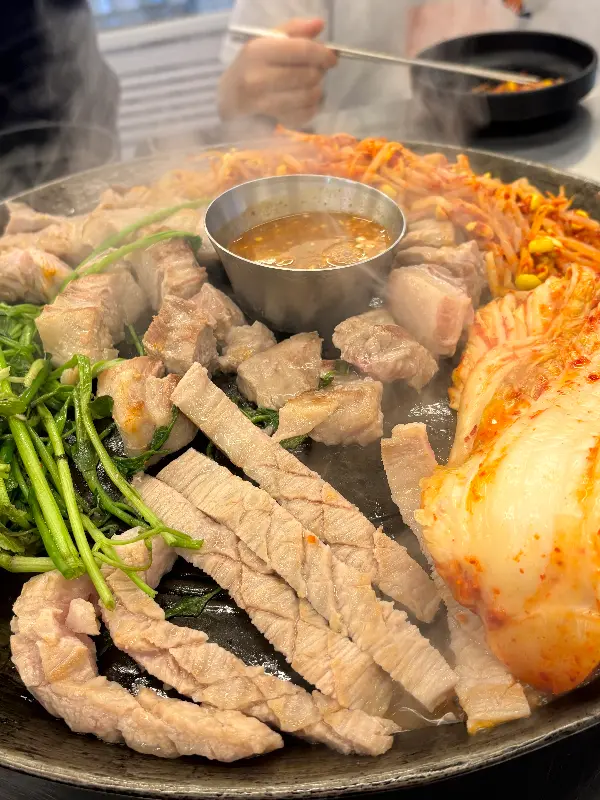 솥뚜껑 위에서 익어가는 두툼한 삼겹살