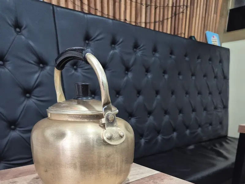 놋쇠 주전자와 검은색 가죽 소파