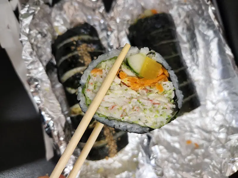 샐러드 김밥을 젓가락으로 집는 모습